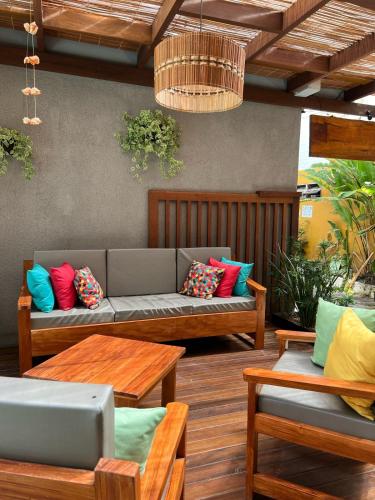 a patio with a couch with colorful pillows on it at Terra Bella Pousada in Morro de São Paulo