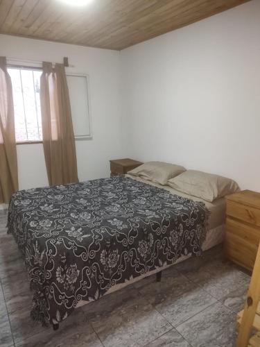 1 dormitorio con 1 cama con edredón negro en Meraki en Guaymallén