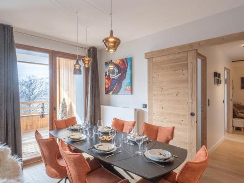 - une salle à manger avec une table et des chaises orange dans l'établissement Appartement confortable, près des pistes, 6 pers., Alpe d'Huez - FR-1-645-53, à Huez