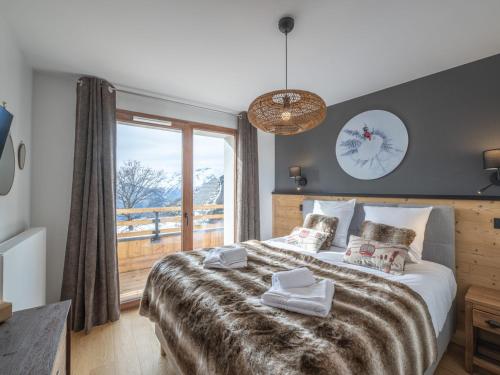 une chambre avec un grand lit avec une grande fenêtre dans l'établissement Appartement 2 chambres, proche pistes, animaux admis, WiFi, parking inclus - FR-1-645-53, à Huez