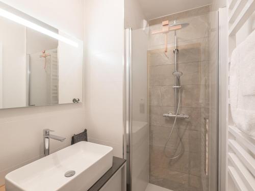 une salle de bain blanche avec une douche et un lavabo dans l'établissement Appartement 2 chambres, proche pistes, animaux admis, WiFi, parking inclus - FR-1-645-53, à Huez