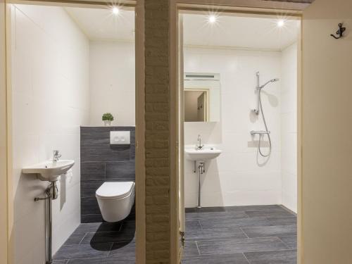 a bathroom with a toilet and a sink and a shower at Cozy home with lots of privacy, in the forest in De Bult