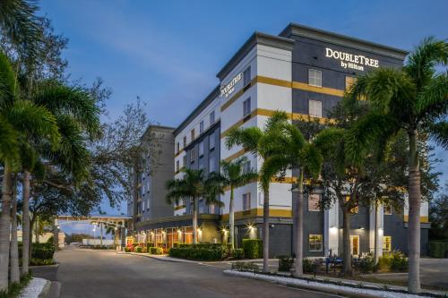 a building with palm trees in front of a street at DoubleTree by Hilton Sarasota Bradenton Airport in Sarasota