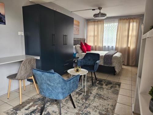 um quarto de hotel com uma cama, uma mesa e cadeiras em Deluxe Guest Suite at Warner Beach em Kingsborough