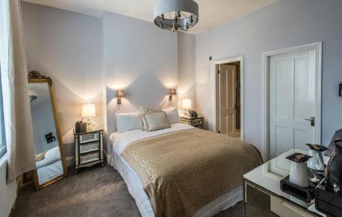 - une chambre avec un grand lit et un miroir dans l'établissement The Walton Hotel, à Nottingham