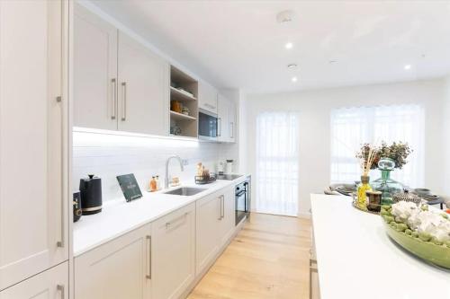 a kitchen with white cabinets and a white counter top at London Central Luxury Stay in London