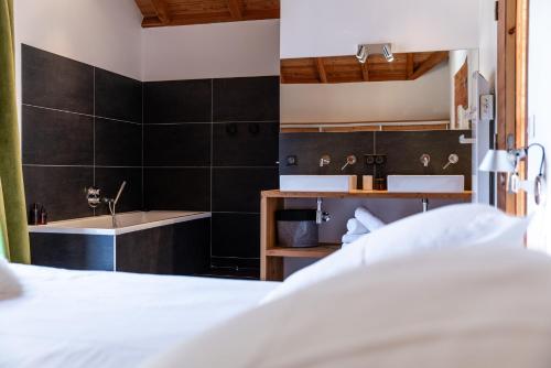 - une chambre avec un lit, une baignoire et un lavabo dans l'établissement Chalet Snowbird 5 étoiles, Serre-Chevalier, à La Salle Les Alpes