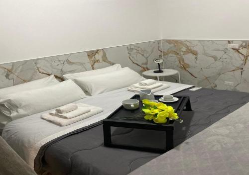 Una cama blanca con una mesa y toallas. en Mergellina Relais 70- Casa vacanze Napoli, en Nápoles