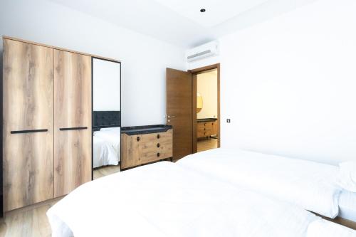 a bedroom with two beds and a large mirror at Harmonija SPA RESORT in Vrdnik