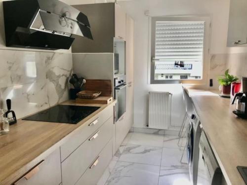 une cuisine avec des placards blancs et un comptoir dans l'établissement Le Bouscat: un superbe appartement en résidence, à Le Bouscat