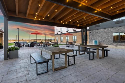 a patio with tables and benches and a painting of a sunset at The Winslow - Winslow, AZ in Winslow