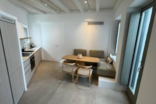 Una pequeña cocina con una mesa y un sofá. en Vivant Naousa Residence 4, en Naousa