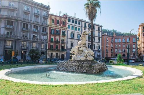 una fuente en medio de una ciudad con edificios en Mergellina Relais 70- Casa vacanze Napoli, en Nápoles