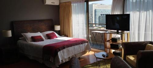 a hotel room with a bed and a large window at Suites El Golf San Sebastian 2711 Las Condes in Santiago