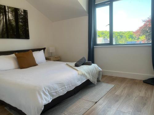 a bedroom with a bed and a large window at Boutique Townhouses Letterfrack Village - Entrance to Connemara National Park in Galway