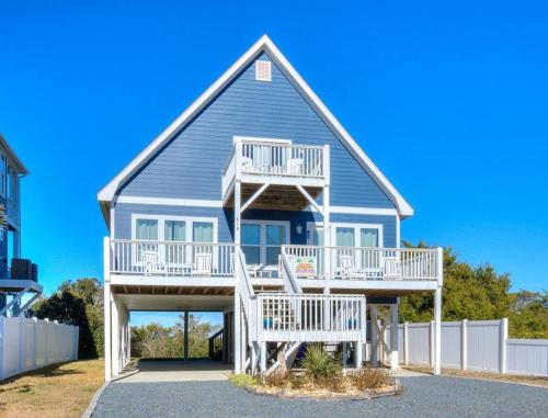 a blue house with white stairs and a porch at A-Frameable Moment in Oak Island