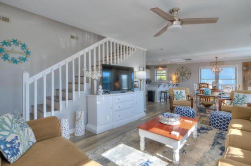 a living room with a couch and a tv at A-Frameable Moment in Oak Island