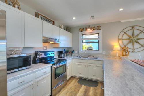 a large kitchen with white cabinets and a large wheel at A-Frameable Moment in Oak Island
