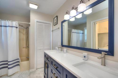 a bathroom with a sink and a mirror and a shower at A-Frameable Moment in Oak Island