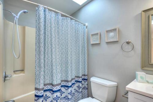 a bathroom with a shower curtain and a toilet at A-Frameable Moment in Oak Island