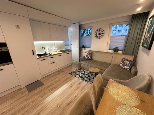 a living room with a couch and a kitchen at Studio z sypialnią na Zatorzu in Słupsk