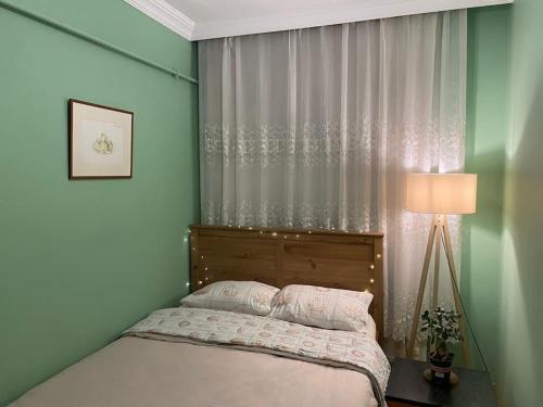 a bedroom with a bed and a lamp and a window at Üsküdar merkezde ve Kadıköy’e 5 dk uzaklıkta ev in Istanbul