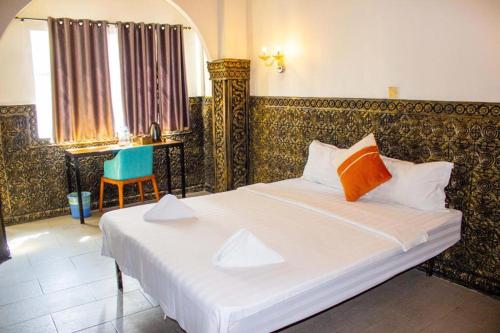 Le Hotel Phnom Penh tesisinde bir odada yatak veya yataklar