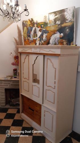 une armoire blanche dans une pièce avec un tableau sur le mur dans l'établissement Barracas Central Feijoo, à Buenos Aires