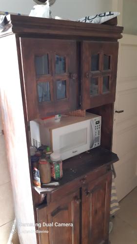 d'une armoire en bois avec un four micro-ondes dans la cuisine. dans l'établissement Barracas Central Feijoo, à Buenos Aires