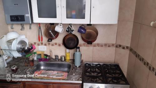Il comprend une cuisine équipée d'un évier et d'une cuisinière. four supérieur dans l'établissement Barracas Central Feijoo, à Buenos Aires