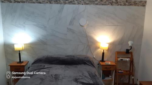 - une chambre avec un lit et deux lampes sur les tables dans l'établissement Barracas Central Feijoo, à Buenos Aires