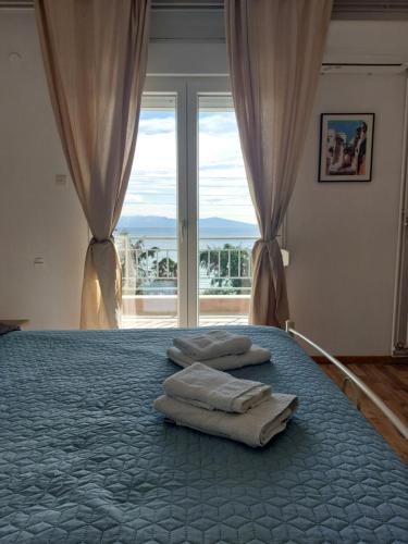 1 dormitorio con 1 cama con 2 toallas en Nicola's House - Palio, en Kavala