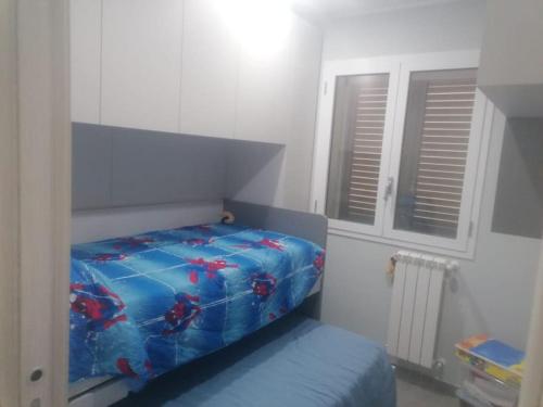 Schlafzimmer mit einem Bett mit blauer Decke in der Unterkunft Casa vacanze indipendente in campagna in Solarino