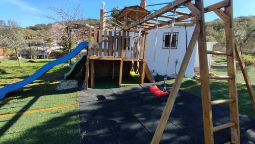 a playground with a slide and a swing set at Casa Rural Bellavista Ronda in Ronda