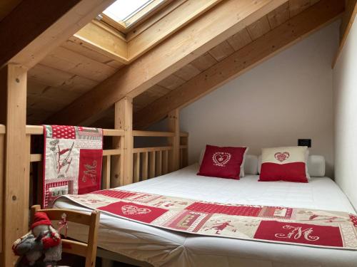 Zimmer im Dachgeschoss mit einem Bett mit roten Kissen in der Unterkunft Dolomiten Dream House in Ziano di Fiemme
