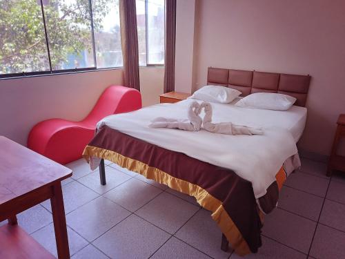 Un dormitorio con una cama con una toalla. en Hostal La Dulce Vida, en Trujillo