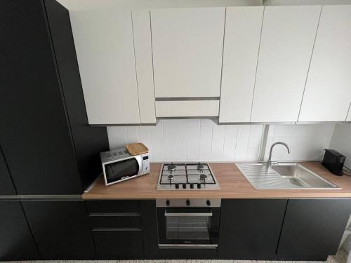 a kitchen with a stove and a microwave on a counter at Milan Apartment - Città Studi: 75mq for you in Milan