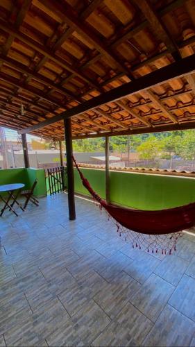 a hammock in a building with a green wall at Paúba House in São Sebastião