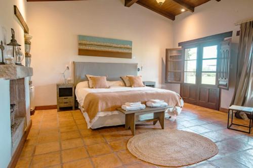 a bedroom with a large bed and a fireplace at Eunoia casa de campo in Sinsacate