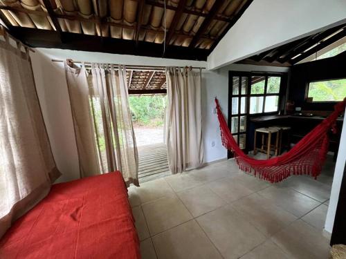 een woonkamer met een rode bank en een hangmat bij Espaço Tempo Eventos e Estadias in Uruçuca
