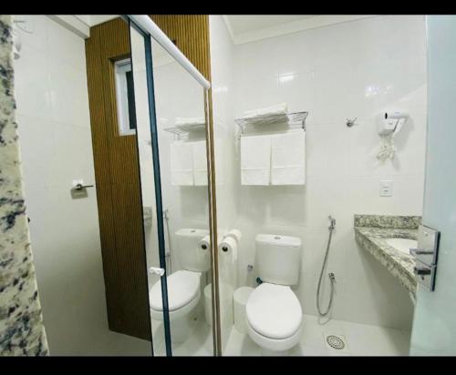 a white bathroom with a toilet and a shower at Spazzio diRoma c/Acqua Park!! in Caldas Novas