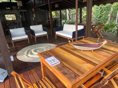 een houten tafel en stoelen op een veranda bij Espaço Tempo Eventos e Estadias in Uruçuca