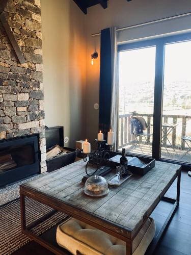 a living room with a wooden table and a fireplace at Chalé Mezio in Mezio