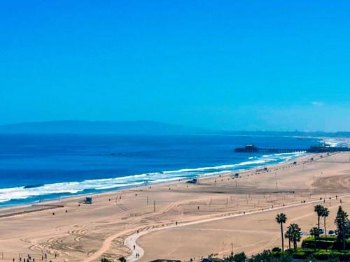 a view of a beach with palm trees and the ocean at Ocean View Santa Monica Three-Bedroom Apartment in Los Angeles