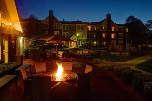 a table with a fire in the middle of a patio at Residence Inn Saddle River in Saddle River