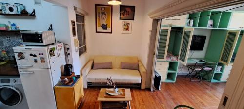 Habitación pequeña con sofá y nevera. en Departamento completo amplio en Recoleta - Dos ambientes en Buenos Aires