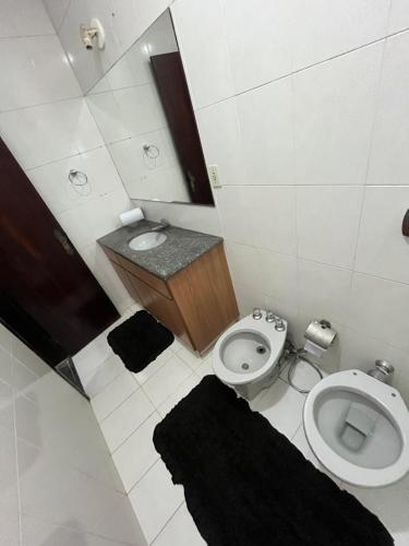 a small bathroom with a toilet and a sink at Hostel e Restaurante Dona Lu in Itaperuna