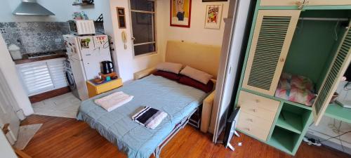 Dormitorio pequeño con cama y nevera en Departamento completo amplio en Recoleta - Dos ambientes en Buenos Aires