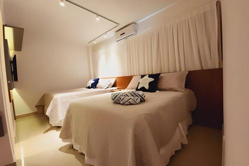 een slaapkamer met 2 bedden en een spiegel bij JPN87 - Duplex em condomínio fechado próx. à praia in Natal