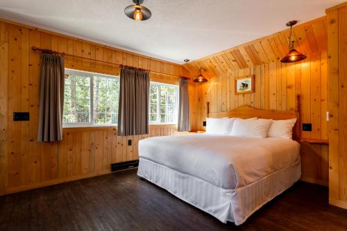 a bedroom with a large bed and a window at Pine Bungalows in Jasper